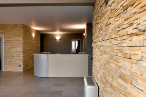 interno reception con rivestimento Scaglia Carsica Melange Pietra Rigenerata